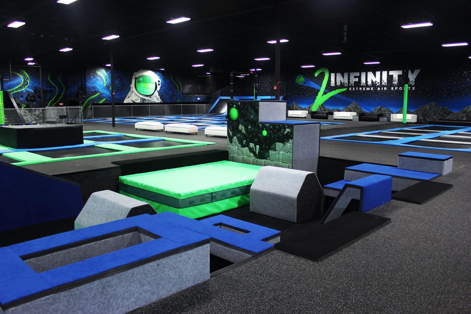 Open floor at DEFY Lakeland showing trampolines and agility boxes.