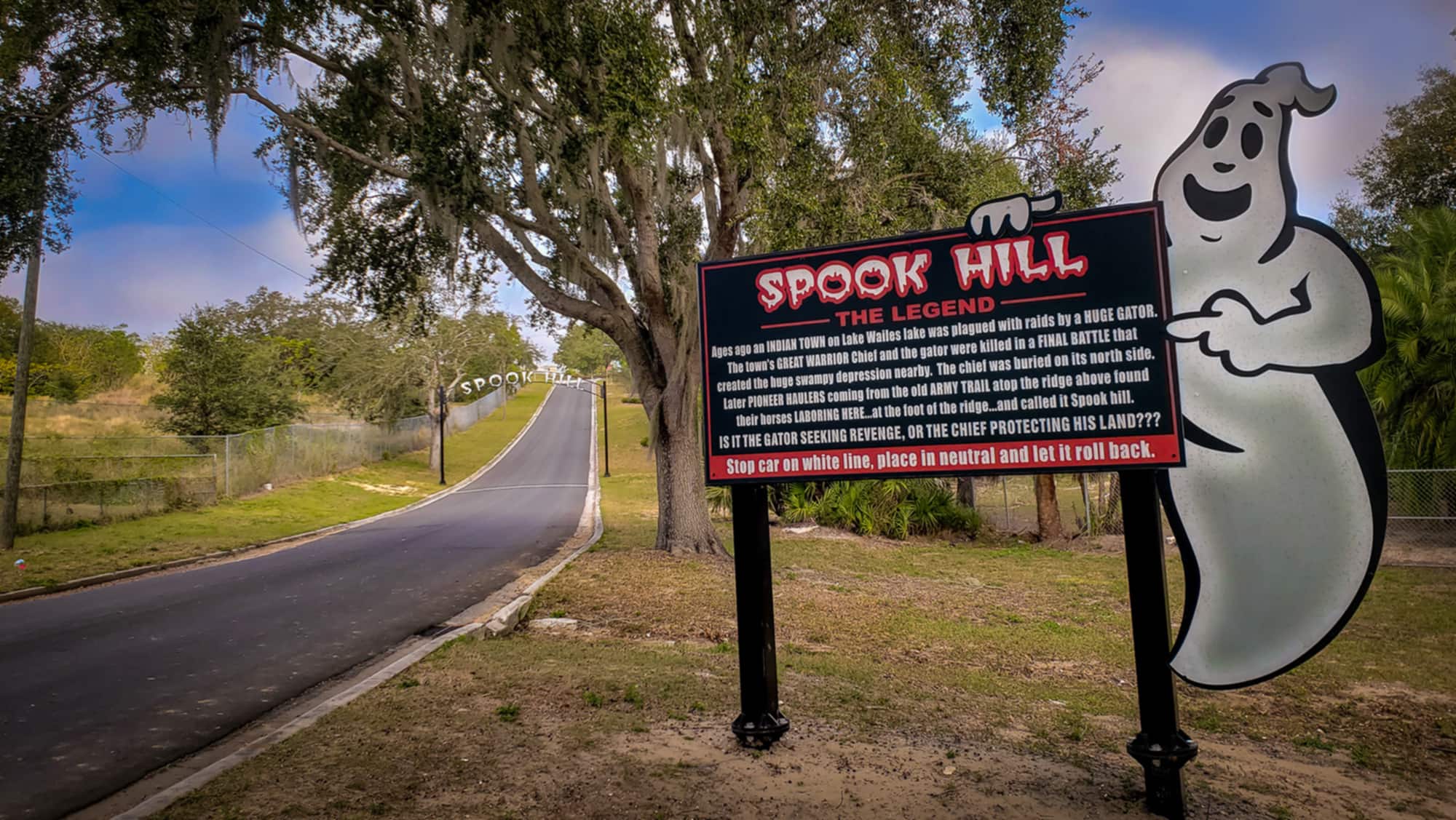 Road and sign explaining history of Spook Hill in Lake Wales, FL
