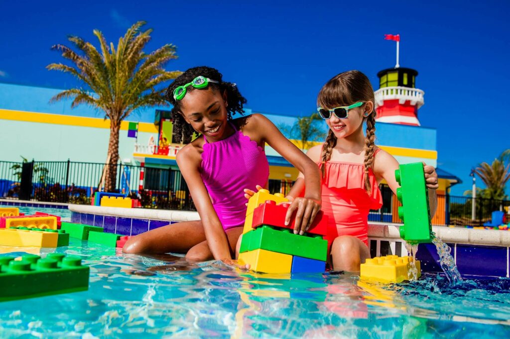 2 young girls playing with LEGO bricks in LEGOLAND Beach Retreat pool