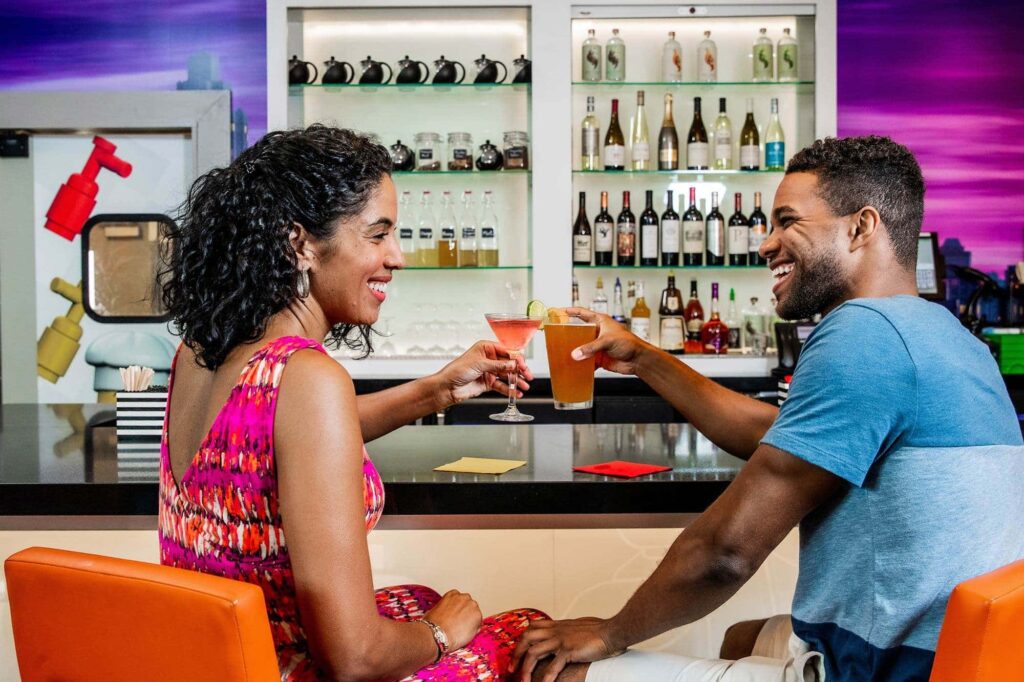 2 adults enjoying cocktails at Skyline Lounge inside onsite hotel at LEGOLAND