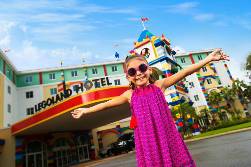 young girl in pink dress and pink sunglasses outside LEGOLAND Hotel in Winter Haven, FL