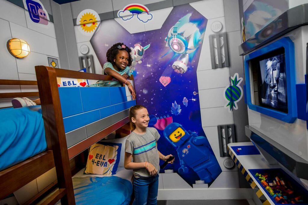 2 girls kids room with bunk beds and TV in LEGO Movie World themed room at LEGOLAND Hotel in Florida.