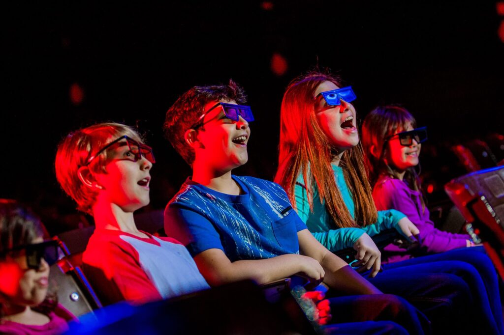 5 kids wearing 3D glasses inside LEGOLAND Fun Town Theater in Florida
