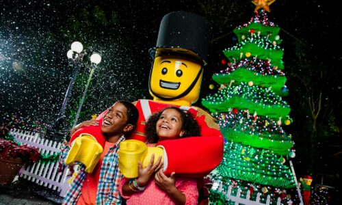 Santa and 2 kids with Christmas tree in background during Holidays at LEGOLAND