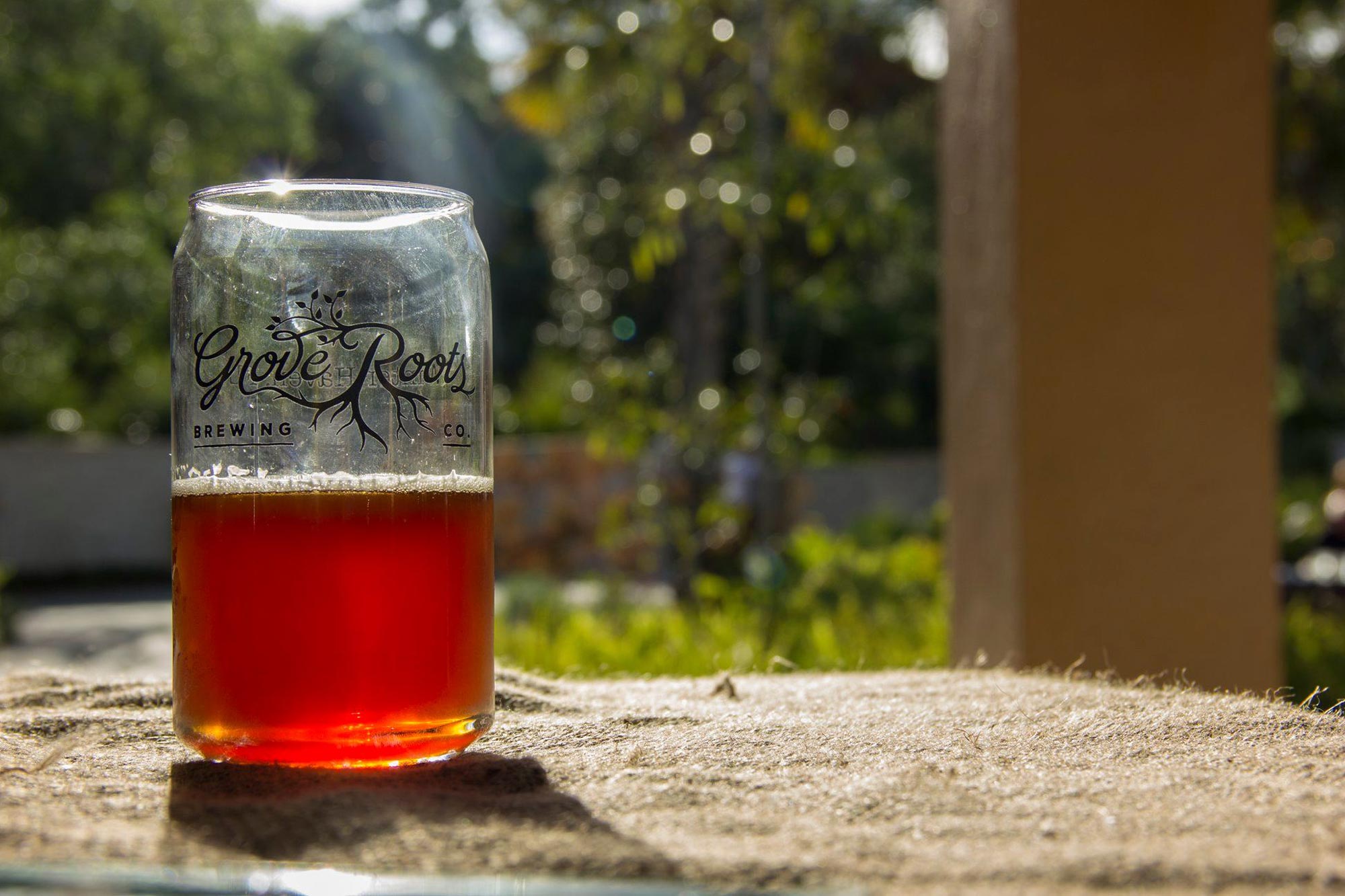 Grove Roots Brewing Co. pint half filled with beer promoting Uncasked Concert at Bok Tower Gardens